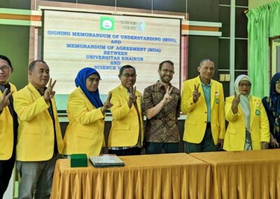 Ten people standing in a row, with Indonesians wearing yellow coats